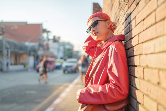 Gen z girl leather fashion with punk Asian woman tourist of local city Southeast Asia travel trendy pink hairstyle young female punk traveler walking around in town