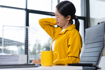 Businesswoman stretches to ease office syndrome from prolonged sitting.