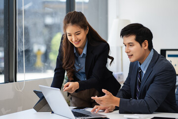 Fototapeta premium Business team analyzing documents, graphs, and data with a laptop, tablet, and smartphone. Collaboration, strategy, and success in a modern office.