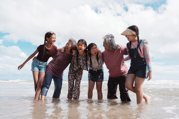 Healthy retirement lifestyle of Asian seniors with daughters and kids, enjoying joyful beach together. Representing wellness, freedom, love, and happiness in later years.