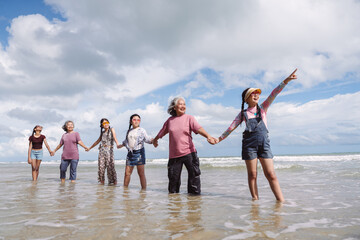Asian family enjoying beach travel together, generations. retirement wellness, love, and joyful...