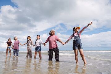 Asian family enjoying beach travel together, generations. retirement wellness, love, and joyful...