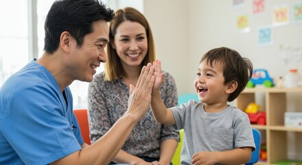 A cheerful child high-fives a medical professional. The mother watches smiling, in a colorful room with sunlight and furniture