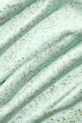 The texture of a mint body scrub with particles. Close-up