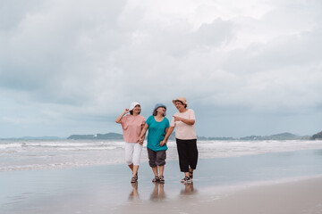 Insurance and retirement lifestyle concept with elderly women walking happily on the beach,...