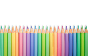 A row of wooden pastel pencils. Bright happy tones. Copyspace for your text.