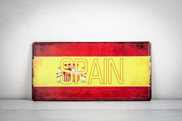 Spain Flag Signboard Against Light Wall Background
