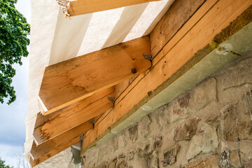 Timber Roof Construction with Insulation on Stone Wall – Sustainable Architecture and Home Renovation