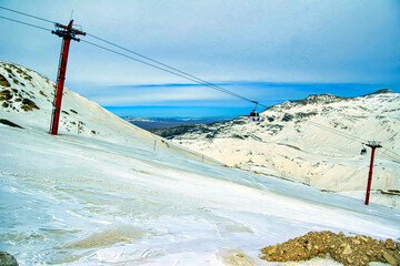 A ski slope with a ski lift in the background