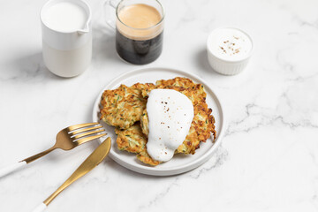 vegetarian zucchini fritters, light marble background