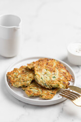 vegetarian zucchini fritters, light marble background