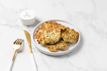 vegetarian zucchini fritters, light marble background