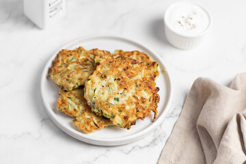 vegetarian zucchini fritters, light marble background