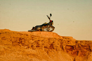 A motorcycle is laying on its side on a rocky hill
