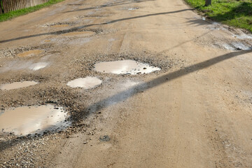 old road with holes and puddles