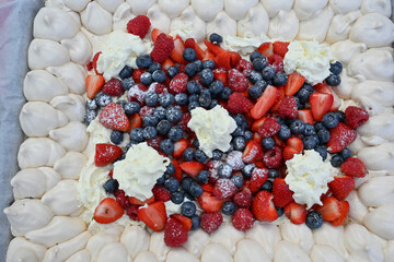 Delicious strawberry tart with blueberries, fresh raspberries and whipped cream, cheesecake, top view. High quality photo