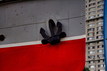 A ship with a red and black anchor on the side