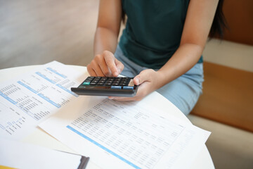 Businesswoman Accountant analyzing investment charts Invoice and pressing calculator buttons over...