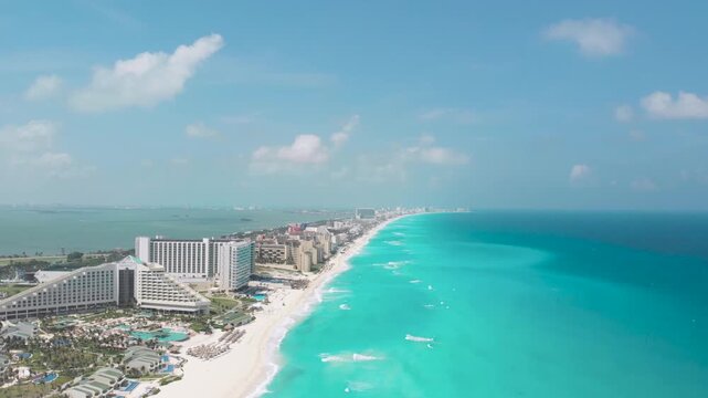 Drone flies forward over Canc&uacute;n Hotel Zone, revealing resorts, white beach, and turquoise sea along Boulevard Kukulc&aacute;n.