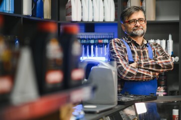 Salesman with crossed arms posing in auto parts store