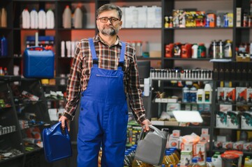 Salesman holding engine oil bottles in auto parts store