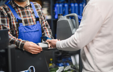 Customer paying with smartphone in auto parts store