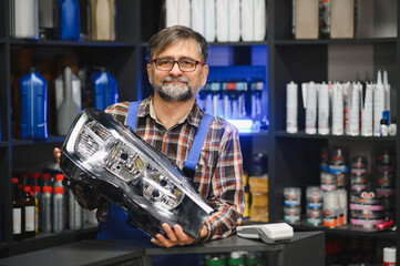 Salesman holding headlight in auto parts store