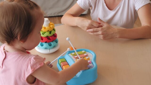 Mother and daughter playing with colorful xylophone