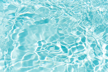 Blue water with ripples on the surface. Defocus blurred transparent blue colored clear calm water surface texture with splashes and bubbles. Water waves with shining pattern texture background.