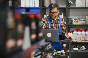 Salesman working at the auto parts store using laptop