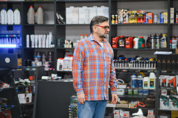 Salesman standing in auto parts store examining products
