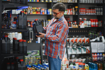Customer choosing motor oil in auto parts store