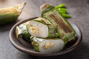 Traditional Indonesian lemper made of sticky rice filled with shredded chicken, wrapped in grilled...