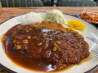 Traditional Korean Pork Cutlet Meal with Side Dishes and Soup on Wooden Table