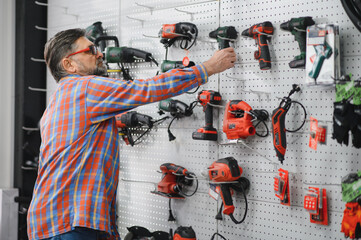 Customer choosing power tool in hardware store