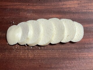 Sliced steamed buns on a wooden cutting board. Classic Chinese wheat - based staple, soft and fluffy. Ideal for breakfast or snack preparations.