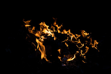 Bright orange flames burning against a dark black background, creating a dramatic and powerful...