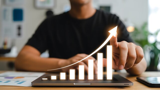 Strategic financial growth and investment success Hand stacks coins on currency atop keyboard, overlaid ascending graph symbolizing increasing profits, economic prosperity, and wealth accumulation.