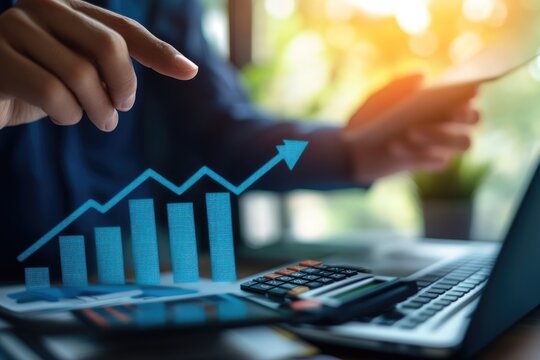 Businessperson using laptop, phone, and documents with upward trending graph overlay