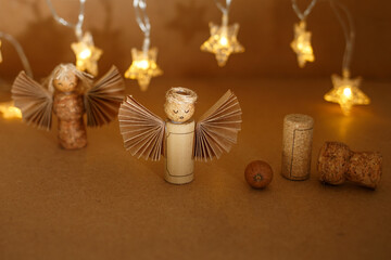 Warm studio setup with handmade cork angels and glowing string lights. Great for craft store ads, sustainable holiday decor shops, or seasonal content for eco-conscious lifestyle brands