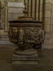 Romanesque baptismal font with biblical scenes carved in stone in the Cathedral of Leon