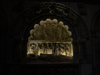 Illuminated stone relief of a medieval tomb scene