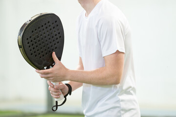 Unrecognizable man holding a padel racket. High quality photo