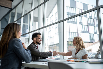 Business people shaking hands after successful meeting in office
