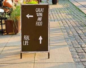 In Copenhagen, Denmark, a sign with Text GREAT WINE AND FOOD or walk on by to real life