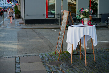 In Copenhagen, Denmark is a table at a restaurant with sign inviting people to visit the restaurant