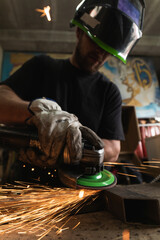 hand of a man sawing metal with an angle grinder