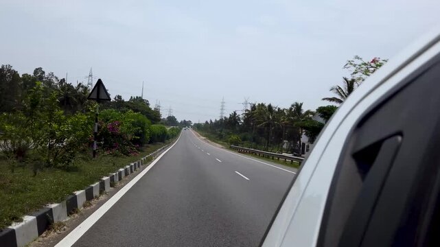 Mysuru, Karnataka, India-April 10 2025; A First person view of a Highway express road journey shot from a moving car in India.
