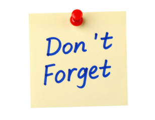 A yellow sticky note pinned with a red pushpin, displaying the handwritten message "Don't Forget" in blue ink.