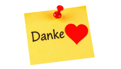 Yellow sticky note with the word "Danke" and a red heart symbol, pinned with a red pushpin.